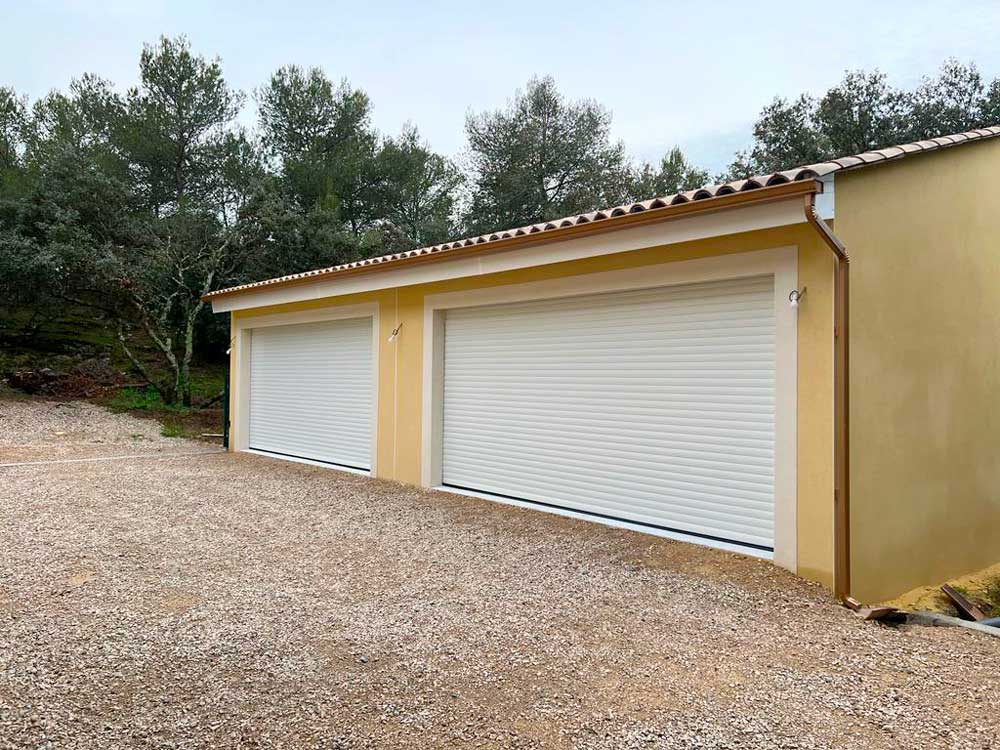 Garage double portes blanches façade jaune enduite toit tuiles