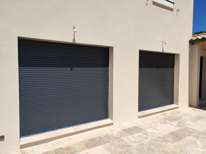 Portes de garage metalliques grises sur facade blanche moderne