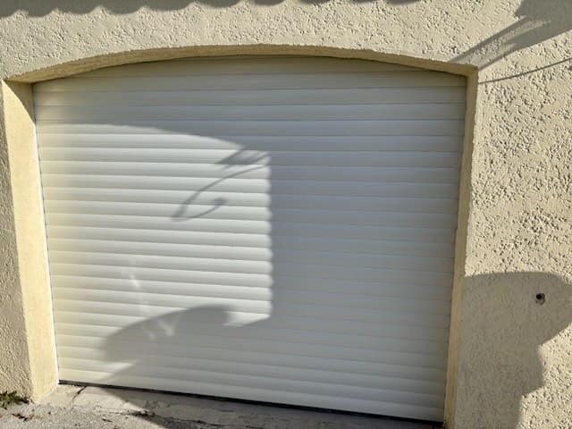 Porte de garage sectionnelle blanche avec cadre en pierre