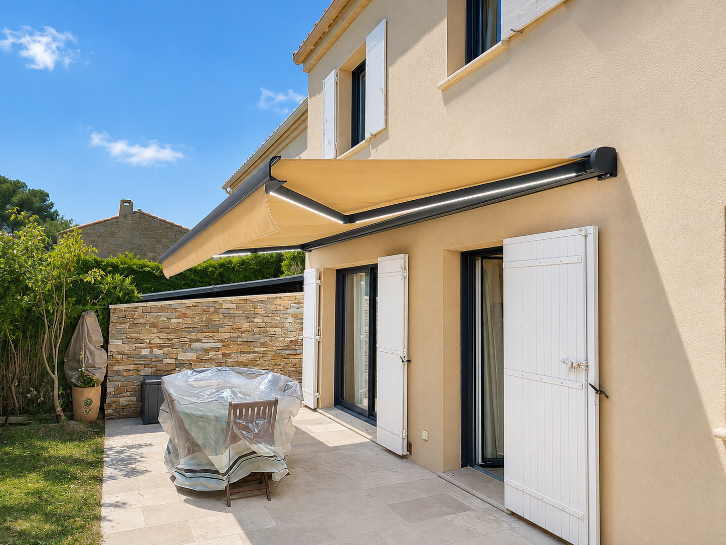 Terrasse moderne avec store banne ocre déployé et portes blanches